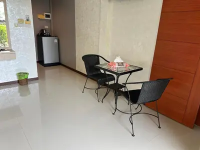 a table and chairs in a room with a refrigerator at Nankanok Resort in Ko Yao Noi