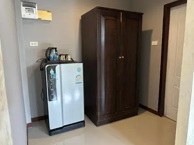 a refrigerator in a room next to a wooden cabinet at Nankanok Resort in Ko Yao Noi