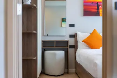 a small bedroom with a bed and a mirror at Space Cherngtalay Condo in Elegant Bang Tao in Ban Thalat Choeng Thale