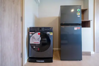 a washing machine next to a refrigerator in a room at Space Cherngtalay Condo in Elegant Bang Tao in Ban Thalat Choeng Thale