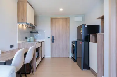 a kitchen with a refrigerator and a table and chairs at Space Cherngtalay Condo in Elegant Bang Tao in Ban Thalat Choeng Thale