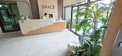 a woman standing at a counter in a room with plants at Space Cherngtalay Condo in Elegant Bang Tao in Ban Thalat Choeng Thale