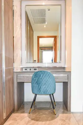 a vanity with a blue chair in front of a mirror at Breeze Villa - Luxury Relaxation in Phuket in Ban Thalat Choeng Thale