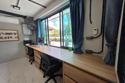 an office with a desk and a window with curtains at Resort Thalang in Phuket