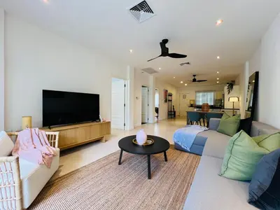 a living room with a couch and a tv at Baan Puri Serviced Apartment by RESAVA in Surin Beach