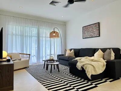 a living room with a couch and a table at Baan Puri Serviced Apartment by RESAVA in Surin Beach