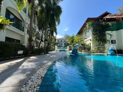 a swimming pool in front of a building at Baan Puri Serviced Apartment by RESAVA in Surin Beach