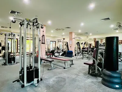 a gym with lots of treadmills and machines at Baan Puri Serviced Apartment by RESAVA in Surin Beach