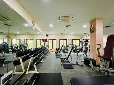 a gym with a lot of treadmills and machines at Baan Puri Serviced Apartment by RESAVA in Surin Beach