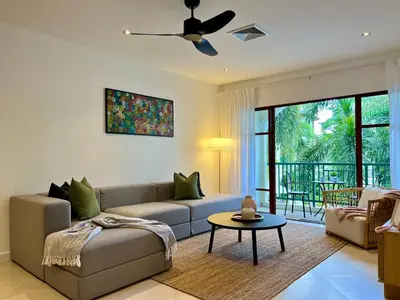 a living room with a couch and a ceiling fan at Baan Puri Serviced Apartment by RESAVA in Surin Beach