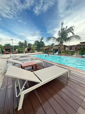 a white bench sitting on a deck next to a swimming pool at Laleuca At Laemhad Kohyaoyai in Ko Yao Yai