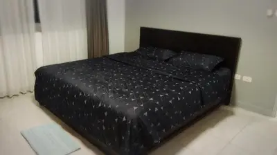 a bed with a black comforter in a bedroom at Supalai Park Phuket City 2 bedrooms for rent in Phuket Town