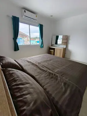 a bedroom with a large bed with a window at Banana Bunkhouse Hostel in Rawai Beach