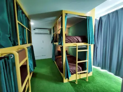 two bunk beds in a room with green carpet at Banana Bunkhouse Hostel in Rawai Beach