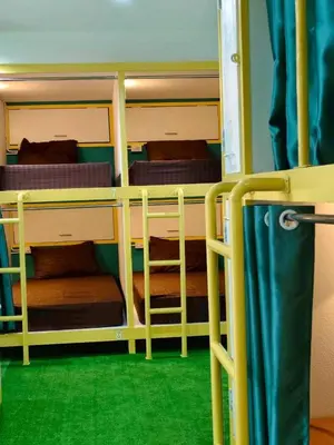 two bunk beds in a room with green carpet at Banana Bunkhouse Hostel in Rawai Beach