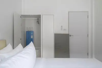 a bedroom with a white bed with white pillows at OldTown Home Phuket 3min walk Central Festival in Ban Rangeng