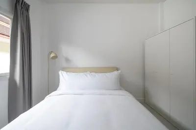 a white bed in a room with a window at OldTown Home Phuket 3min walk Central Festival in Ban Rangeng