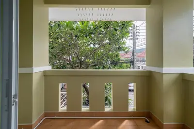 an empty room with a large window and a tree at OldTown Home Phuket 3min walk Central Festival in Ban Rangeng