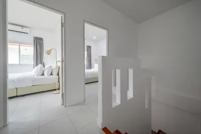 a white bedroom with a bed and a mirror at OldTown Home Phuket 3min walk Central Festival in Ban Rangeng