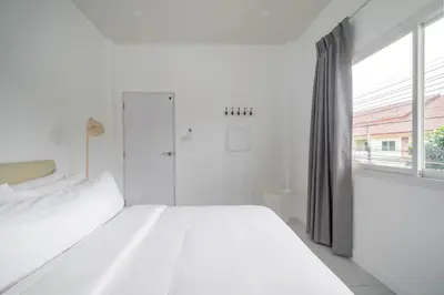 a white bedroom with a bed and a window at OldTown Home Phuket 3min walk Central Festival in Ban Rangeng