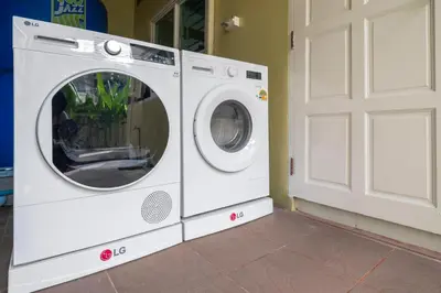 a white washing machine sitting next to a door at OldTown Home Phuket 3min walk Central Festival in Ban Rangeng