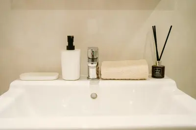 a bathroom sink with a bottle of soap and a towel at Strelitzia Tropical Living at Title Nai Yang in Nai Yang Beach
