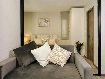 a couch with pillows on it in a living room at Strelitzia Tropical Living at Title Nai Yang in Nai Yang Beach