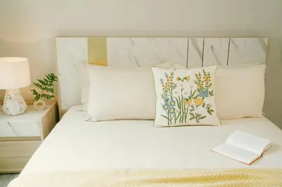 a bed with two pillows and a book on it at Strelitzia Tropical Living at Title Nai Yang in Nai Yang Beach