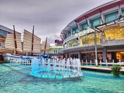 a fountain in the water in front of a building at Le Moon in Patong Beach
