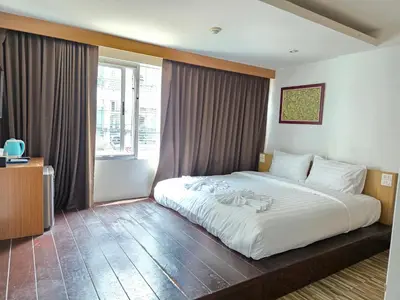 a bedroom with a large white bed and a window at Le Moon in Patong Beach