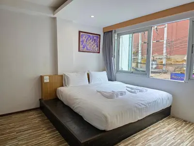 a bedroom with a large bed with a window at Le Moon in Patong Beach