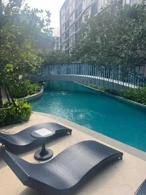a swimming pool with two chairs and a bridge at Luxury cosy condo in Kathu centre in Kathu