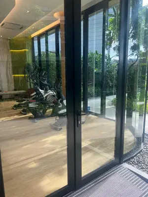 an open glass door with a motorcycle in a building at Luxury cosy condo in Kathu centre in Kathu