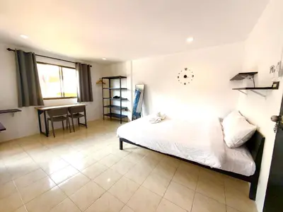 a bedroom with a bed and a table in it at Patong Canal Villa 305 in Patong Beach
