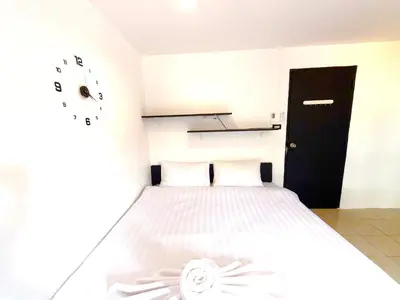 a bedroom with a bed and a clock on the wall at Patong Canal Villa 305 in Patong Beach