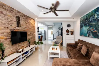a living room with a couch and a brick wall at Modern Kamala Townhouse Hideaway with Shared Pool in Kamala Beach