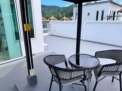 a patio with two chairs and a glass table on a balcony at Modern Kamala Townhouse Hideaway with Shared Pool in Kamala Beach