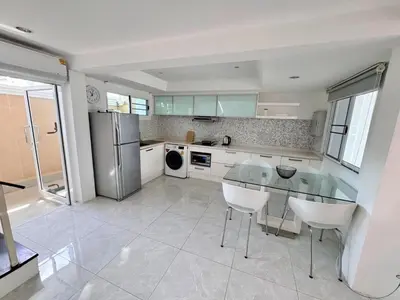 a kitchen with a glass table and white appliances at Modern Kamala Townhouse Hideaway with Shared Pool in Kamala Beach