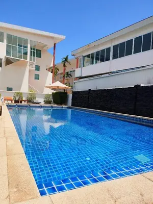 a large blue swimming pool in front of a building at Modern Kamala Townhouse Hideaway with Shared Pool in Kamala Beach