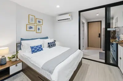 a bedroom with a large white bed with blue pillows at Luxury Resort Style 1 Bedroom Studio near Central in Phuket Town