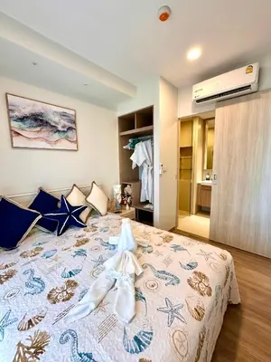 a bedroom with a large bed with blue pillows at Skypark Laguna 2 Bedroom Apartment in Laguna Phuket