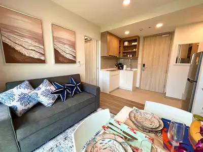 a living room with a couch and a table at Skypark Laguna 2 Bedroom Apartment in Laguna Phuket