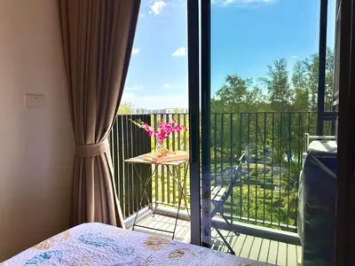 a balcony with a table with a vase of flowers on it at Skypark Laguna 2 Bedroom Apartment in Laguna Phuket