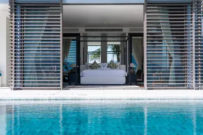 a bedroom with a bed next to a swimming pool at Villa Serenity -30 meter Pool & 6 Bedroom with Cinema Room and Gym in Ko Lek
