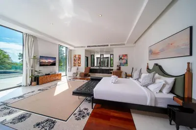a bedroom with a large bed and a living room at Villa Serenity -30 meter Pool & 6 Bedroom with Cinema Room and Gym in Ko Lek