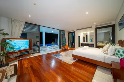 a bedroom with a large bed and a flat screen tv at Villa Serenity -30 meter Pool & 6 Bedroom with Cinema Room and Gym in Ko Lek