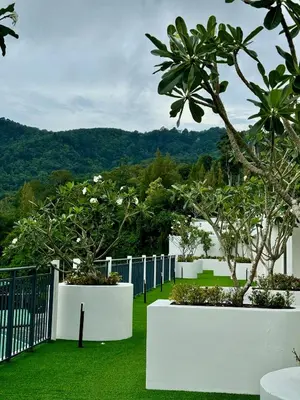 a garden with white fences and trees and grass at Чудесная видовая квартира Fantasea пляж Камала in Kamala Beach