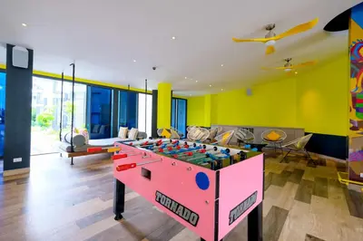a living room with a foosball table in the middle at Cassia Phuket, part of Banyan Group in Bang Tao Beach