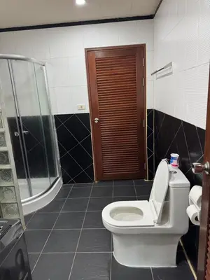 a bathroom with a toilet and a shower at The President Park Condo Nanai, Patong, Phuket in Patong Beach