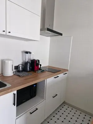 a kitchen with white cabinets and a wooden counter top at Title Halo Nai Yang Тайтл Хало Най Янг operated by OK Group in Nai Yang Beach